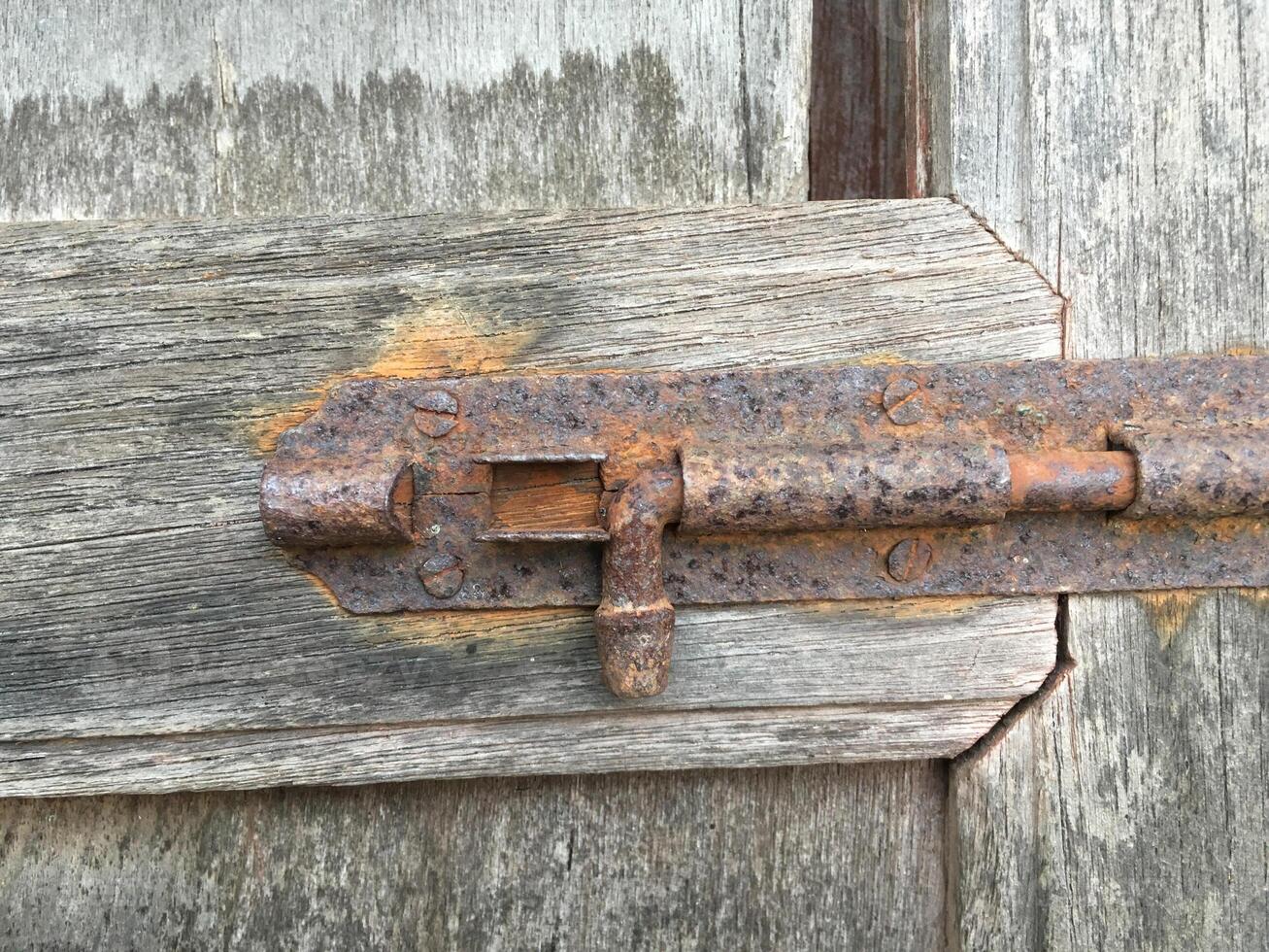 old rusty lock on the old wooden door photo