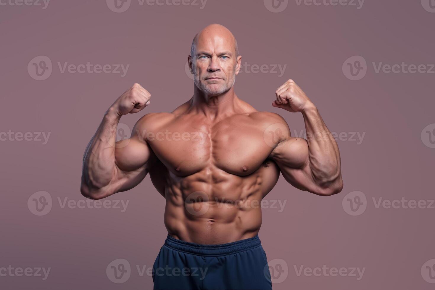 Fit bald man poses showing off his ripped muscles and strength on a neutral background photo