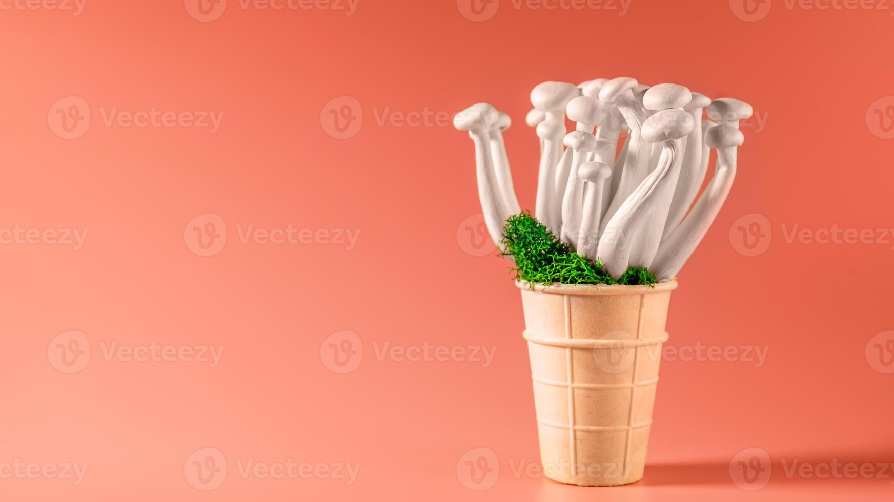 shimeji mushrooms with green moss in an ice cream cone, on bright, colorful, pink background photo