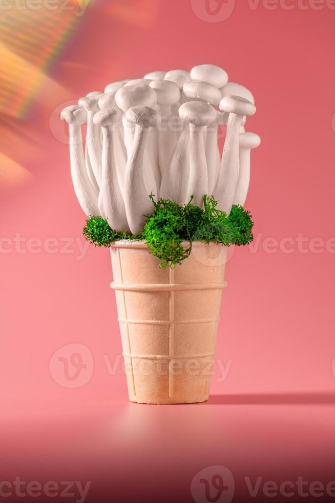 shimeji mushrooms with green moss in green ice cream cone, on pink background photo