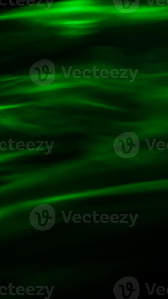 Defocused abstract green background of speed camera movement over glowing lights. A pattern of flashes of light similar to the northern lights photo