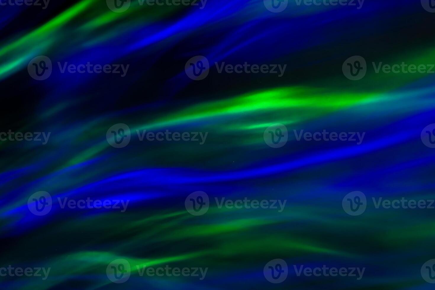 Defocused abstract green and blue background of speed camera movement over glowing lights. A pattern of flashes of light similar to the northern lights photo