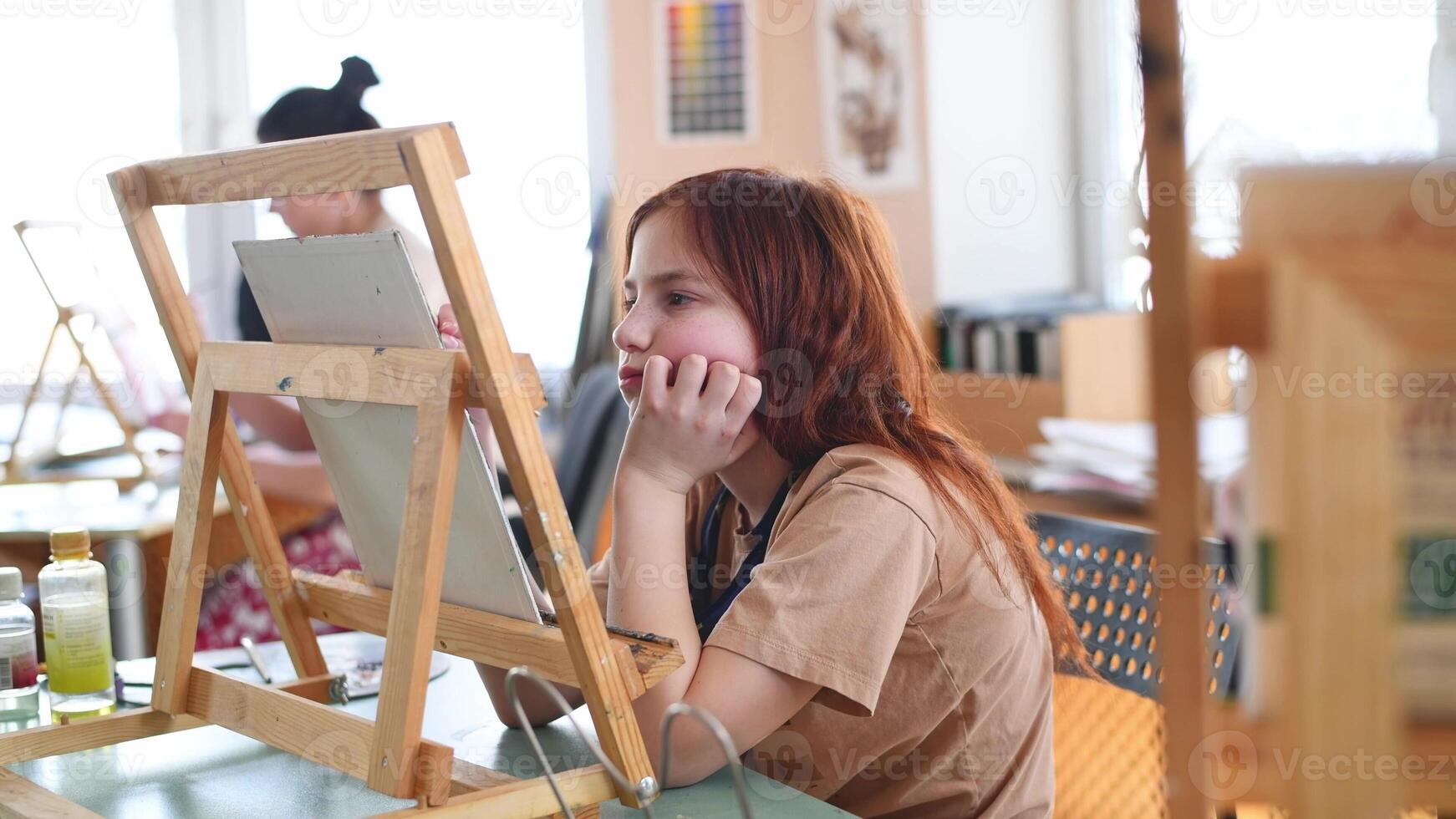 Cute sad pensive girl in art studio painting oil painting. Hobbies, Relaxation, Art Therapy photo