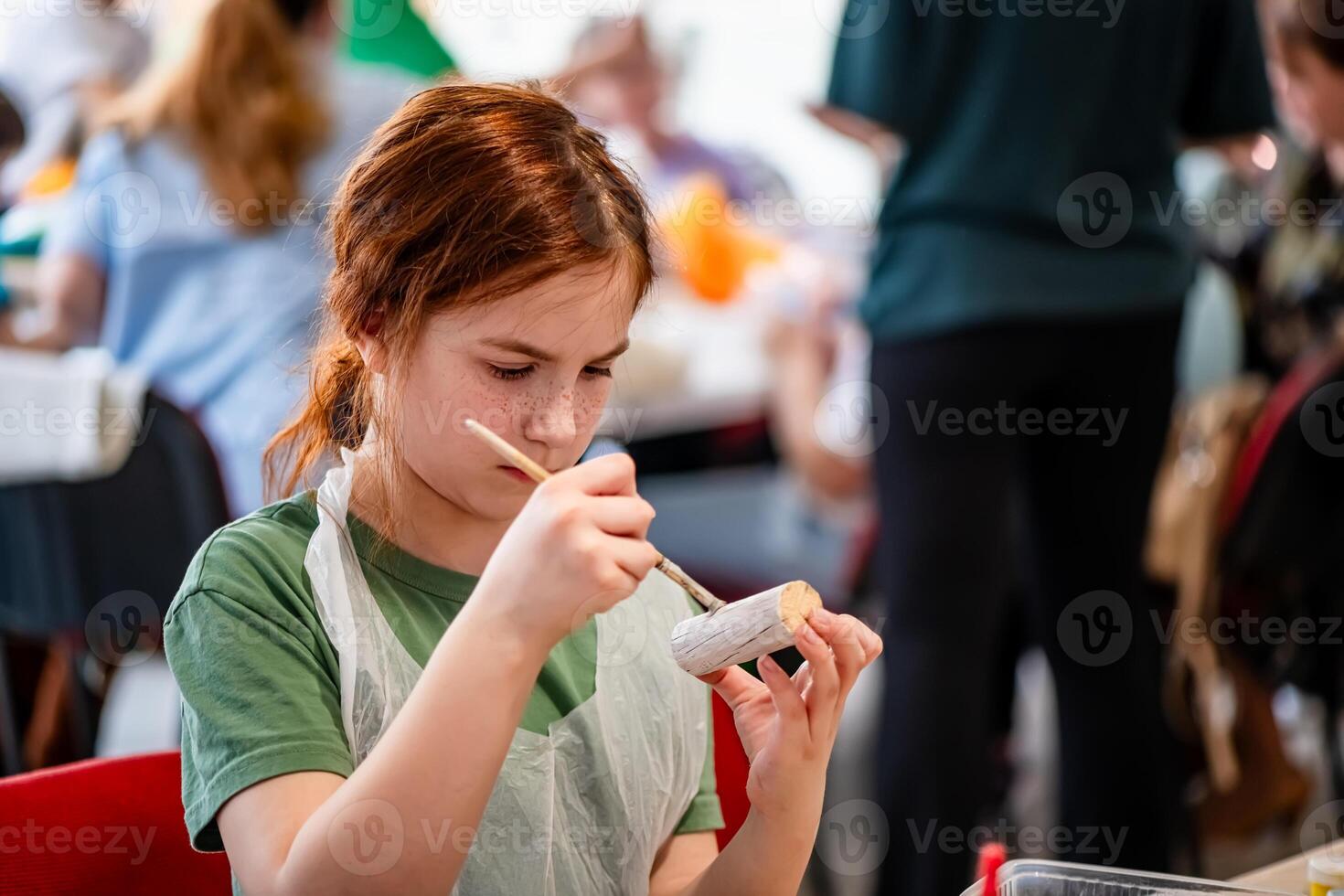 cute teen girl at a master class making a craft from wood, exhibition of crafts, crafts fair, education, master classes photo