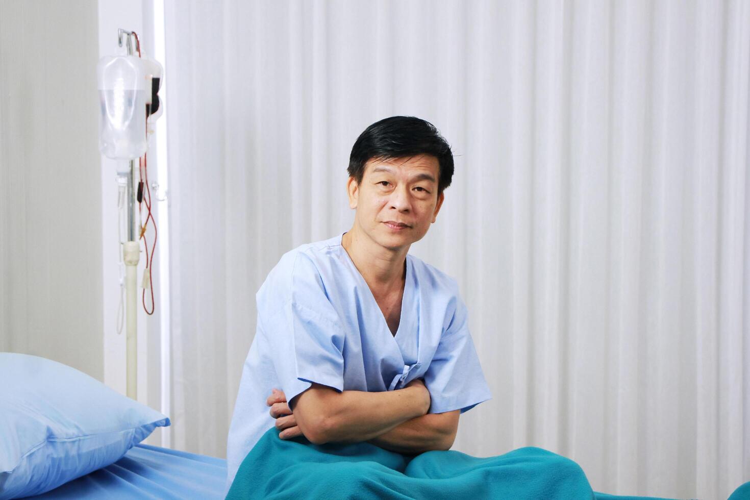 Smiling Asian Old man sitting on bed in healing room and sterile treatment of infections and Lung infection from covid 19 virus in hospital of Thailand. Healthcare and Elderly society Concept. photo