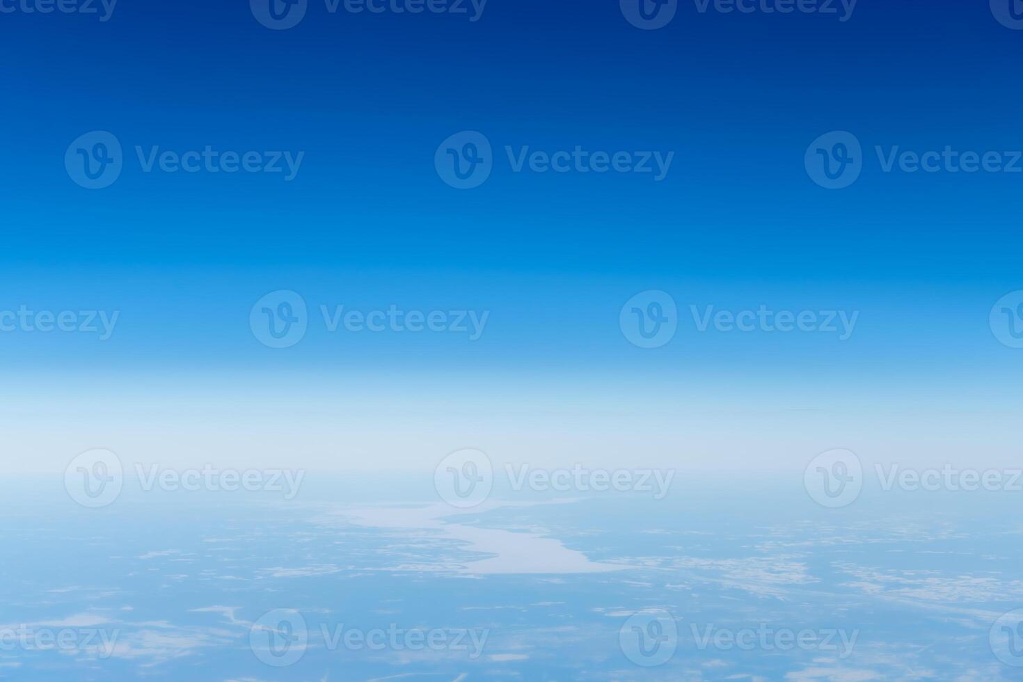 Beautiful view from the airplane porthole. blue sky, clouds, earth. photo