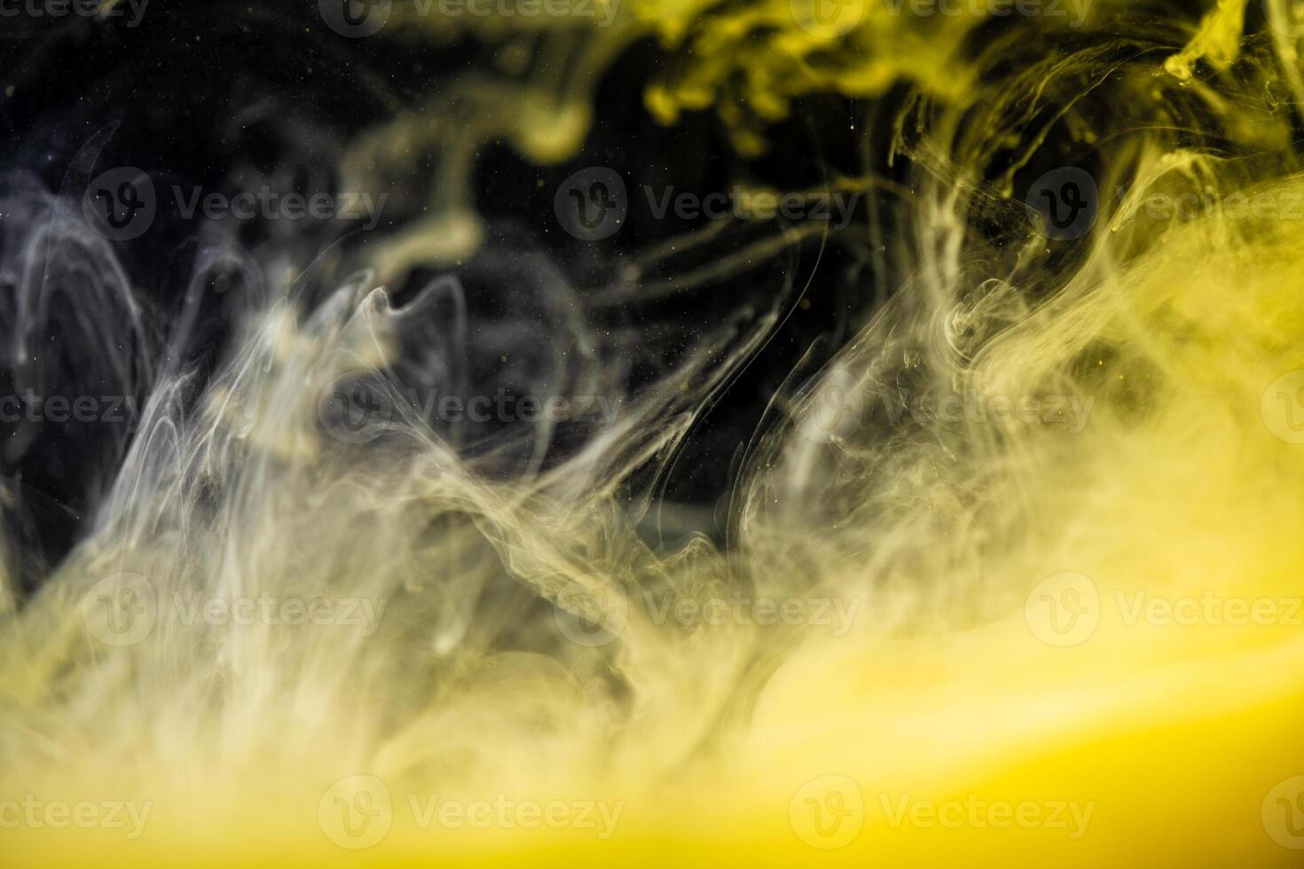 clouds of yellow smoke on a black background, clouds of paint in water, aquarium, abstract background, texture photo