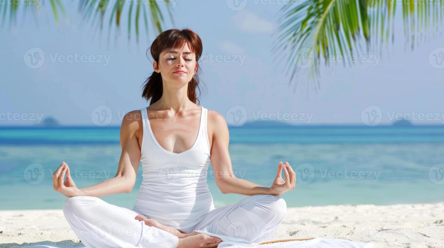 Beautiful American woman practicing yoga at seashore photo