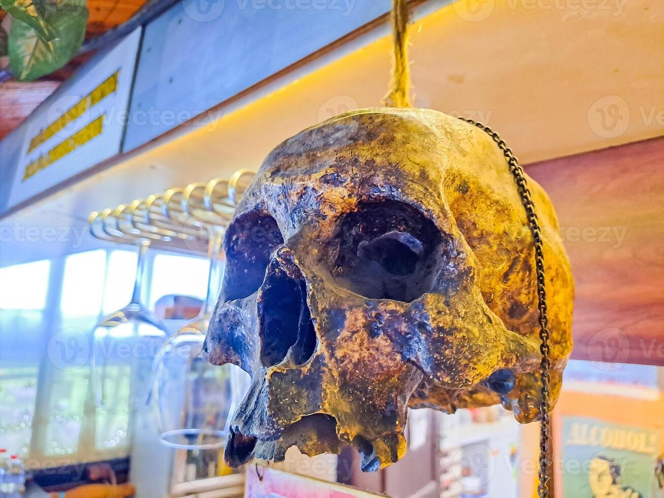 A human skull is suspended over a bar in a rustic country bar in Czech photo