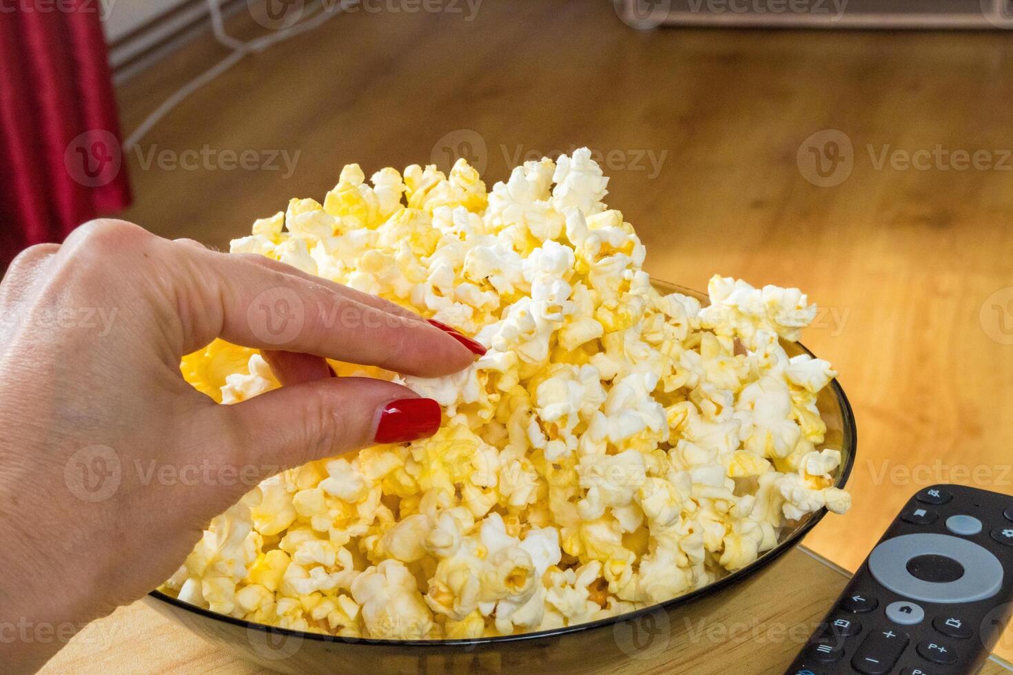 woman Watching smart TV and using remote controller popcorn for watching a movie photo