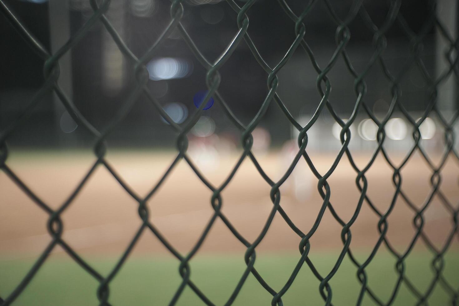 there is a baseball field behind a fence with a baseball field in the background photo