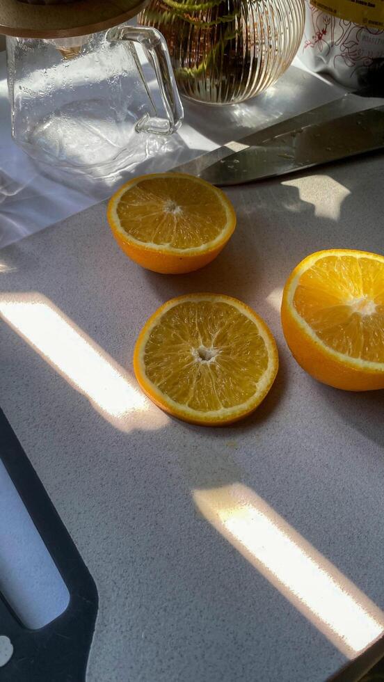 there are four oranges cut in half on a cutting board photo
