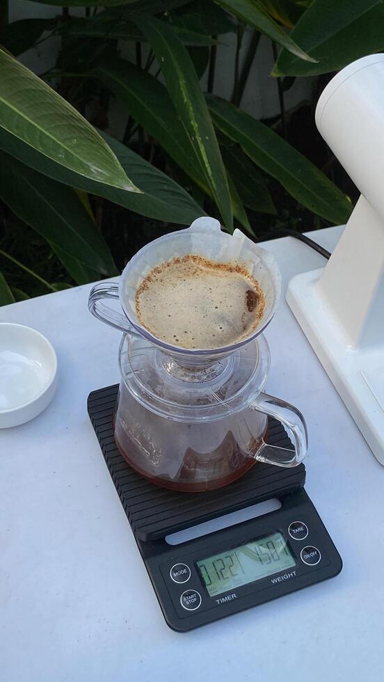 there is a coffee pot on a scale with a cup of coffee photo