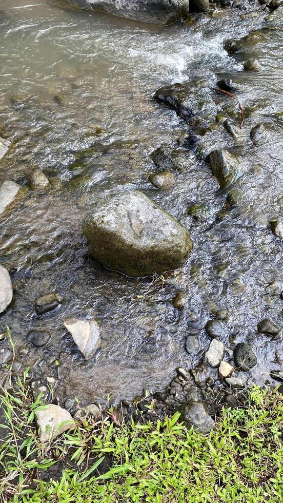 There is a medium sized rock in the middle of the river photo