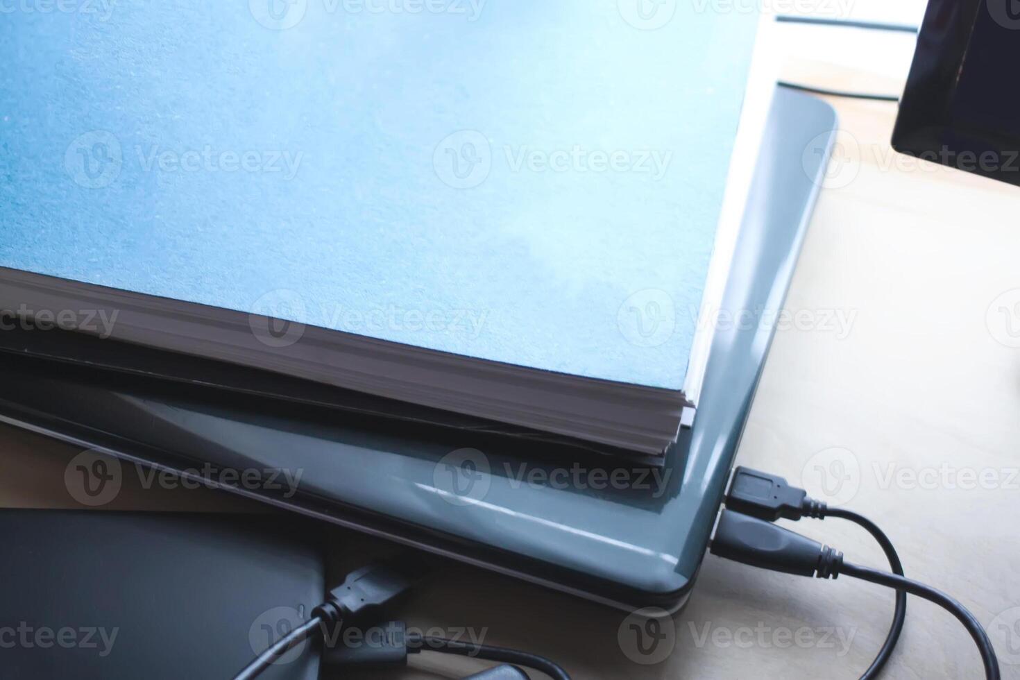 Notebook ,external hard disk and paper pad on wooden background. photo