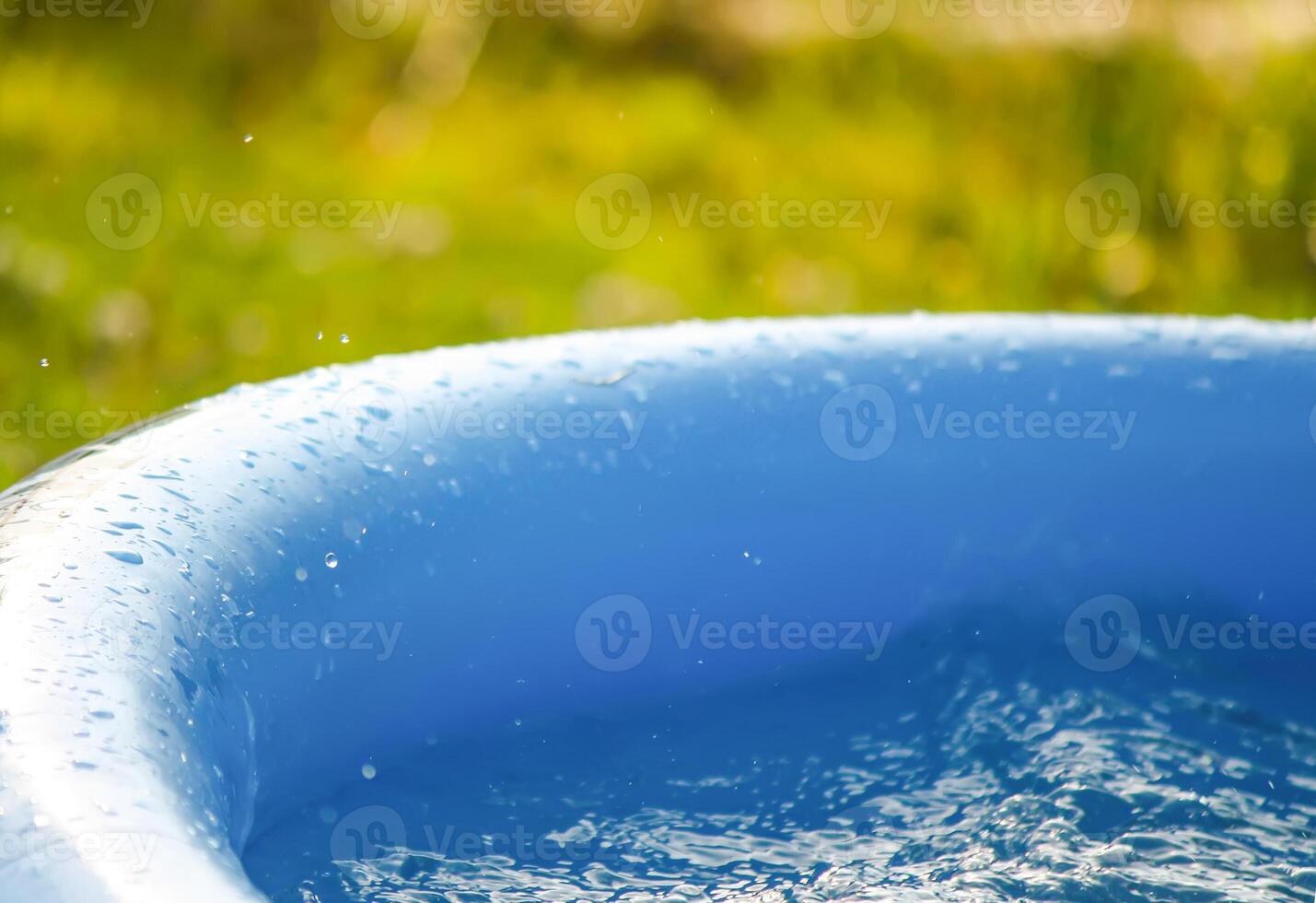 Little girl playing in swimming pool outdoors at summer. photo