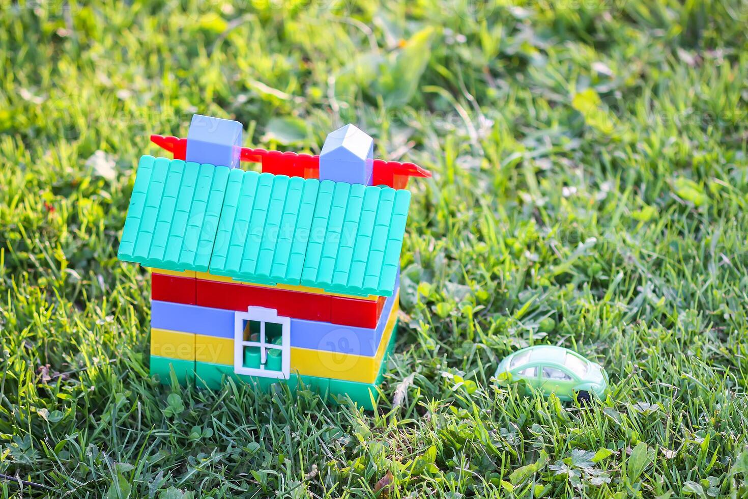 Toy house on green summer meadow background photo