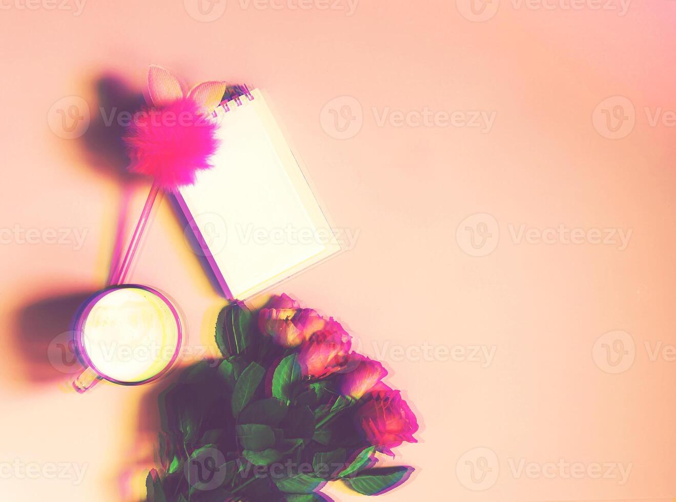 The cup of hot coffee, empty notepad with funny pen and bouquet of fresh roses on soft pink background. Glitch effect image. photo