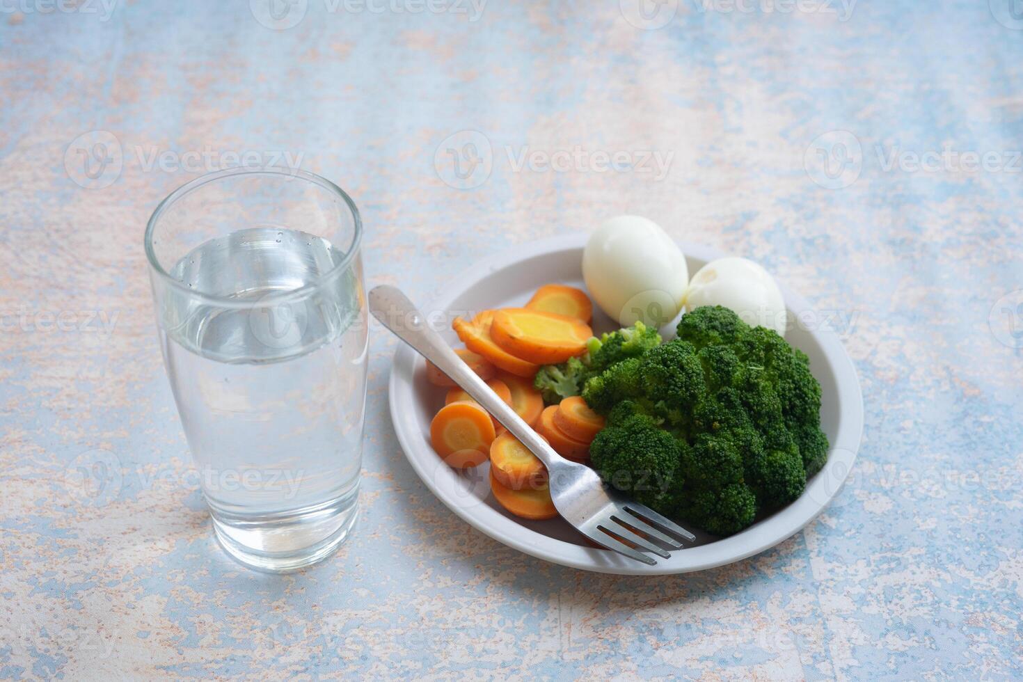 A breakfast diet plate without rice, featuring eggs, carrots, and broccoli, promoting a healthy and balanced meal photo