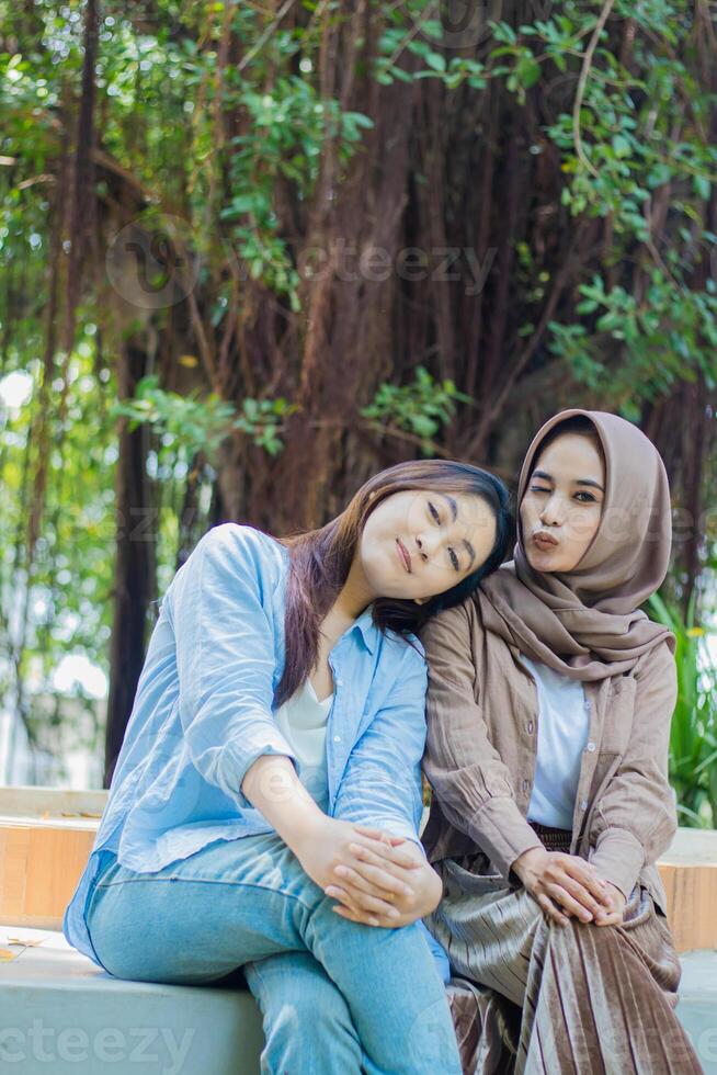 friendship Asian women smiling kissing long time no see looking at camera in campus park. student for the concept of human interest and lifestyle photo
