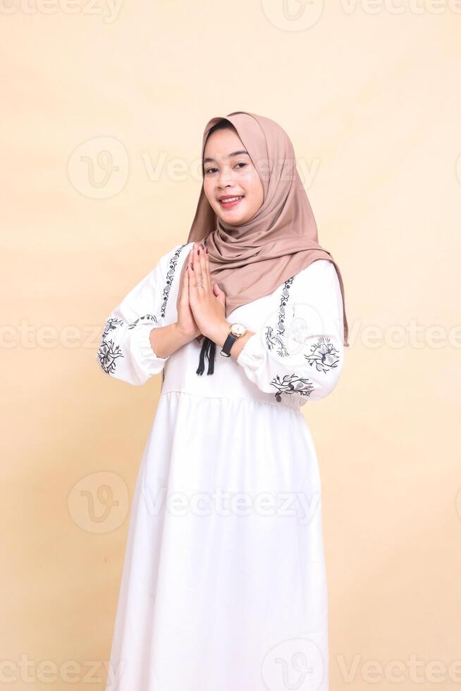 Portrait of a beautiful young Asian Muslim woman wearing a hijab at right angles, smiling, posing to welcome Ramadan and Eid. for advertising, content, banners and Ramadan photo