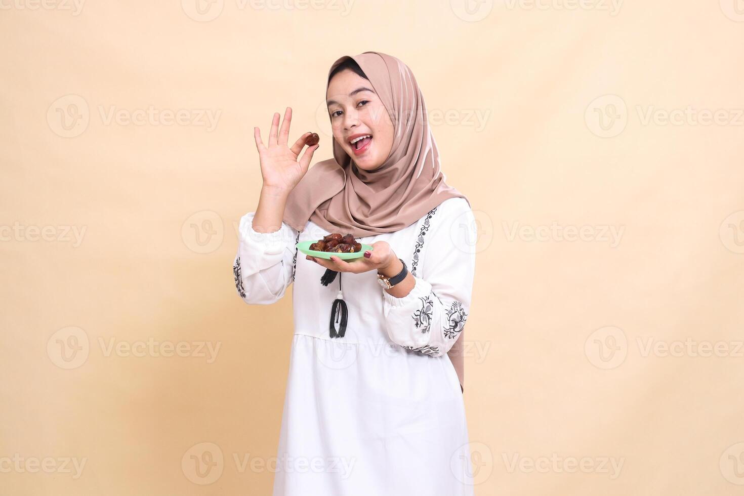 a beautiful indonesia Muslim woman wearing a hijab with a cheerful smile took a date and brought some dates for sahur and breaking the fast. used for advertising, health, Eid and Ramadan photo