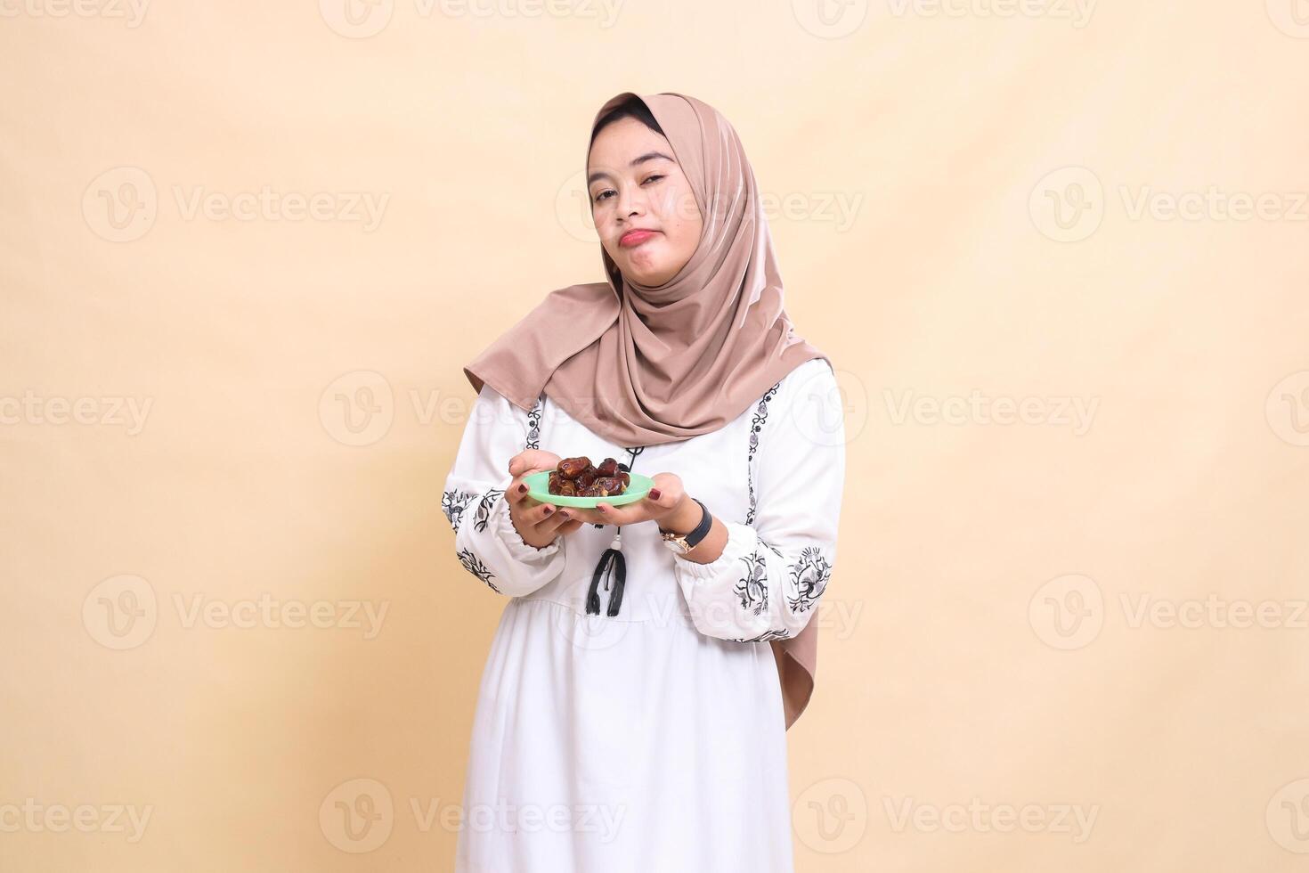 A beautiful Asian Muslim woman wearing a hijab is happy and cheerful bringing dates for sahur and breaking the fast. used for advertising, health, Eid and Ramadan photo