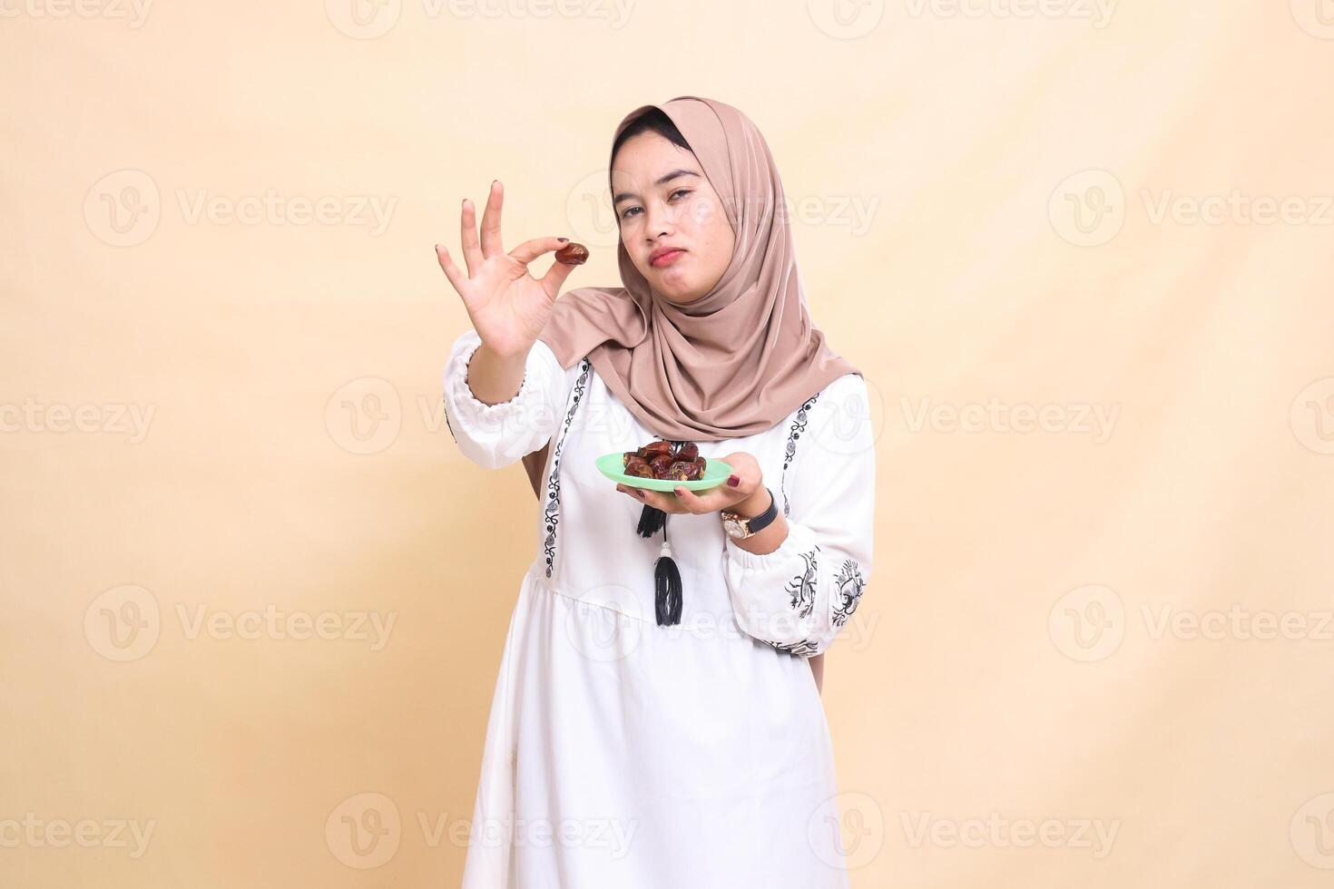 A beautiful Asian Muslim woman wearing a sullen hijab took a date and brought some dates for sahur and breaking the fast. used for advertising, health, Eid and Ramadan photo