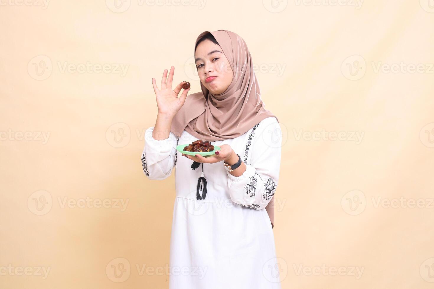 A beautiful Asian Muslim woman wearing a sullen hijab took a date and brought some dates for sahur and breaking the fast. used for advertising, health, Eid and Ramadan photo