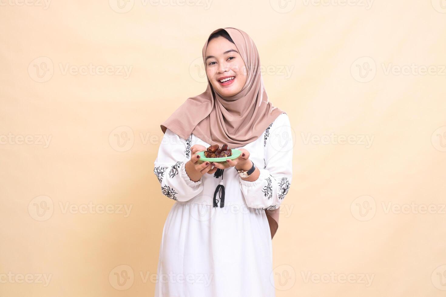 A beautiful indonesia Muslim girl wearing a hijab smiles happily bringing dates for sahur and breaking the fast. used for advertising, health, Eid and Ramadan photo