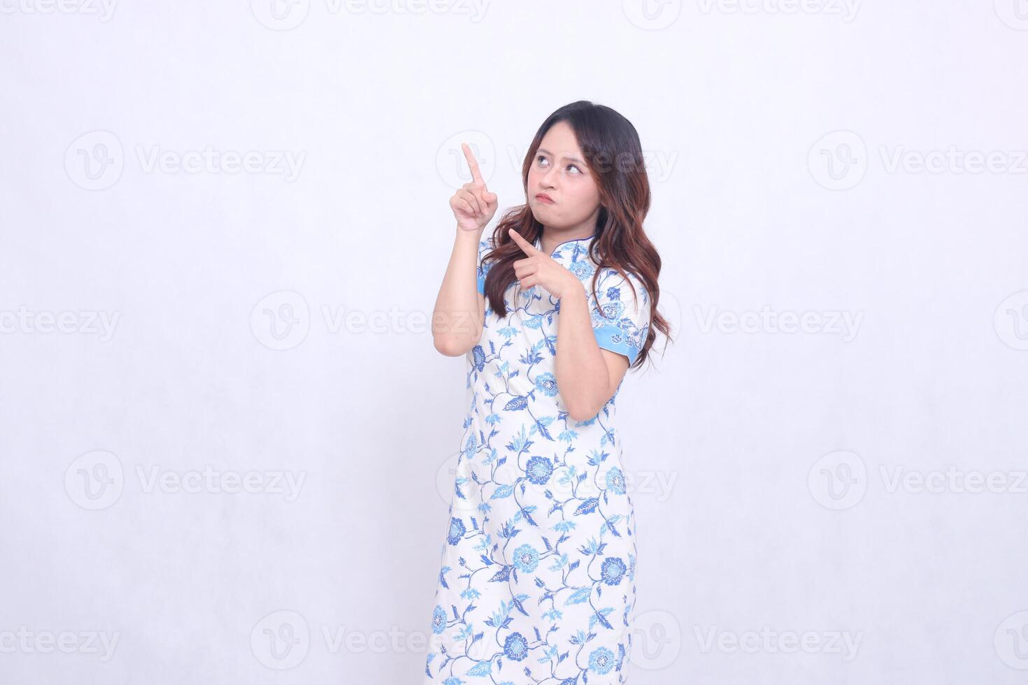beautiful pouting Javanese Chinese woman wearing a modern Chinese dress lyrics and all hands focus on the upper right side on a white background. happy Chinese New Year photo