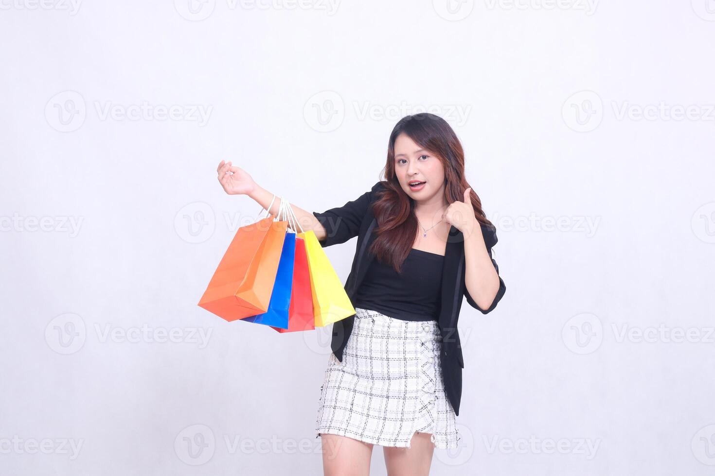 beautiful female customer asian 20s formal elegant office surprised to get discount shopping tote paper bag arm sideways hand sign thumbs up okay isolated white background photo