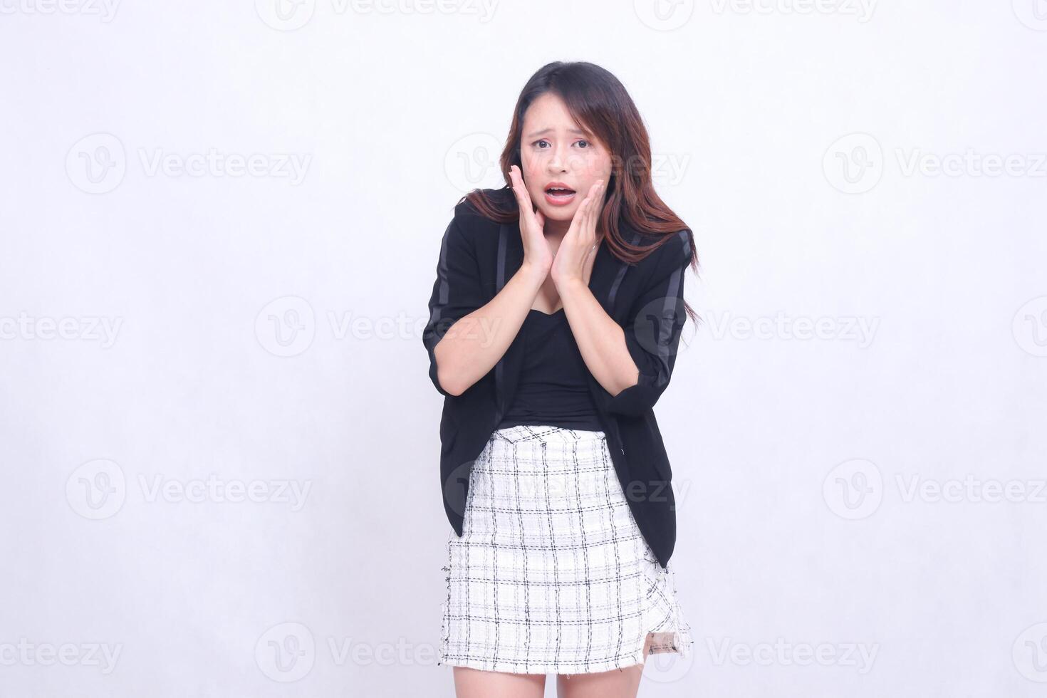 Beautiful Asian Indonesian woman in her 20s in the office is really shocked with her hands in the mouth area slightly bent isolated on a white background photo