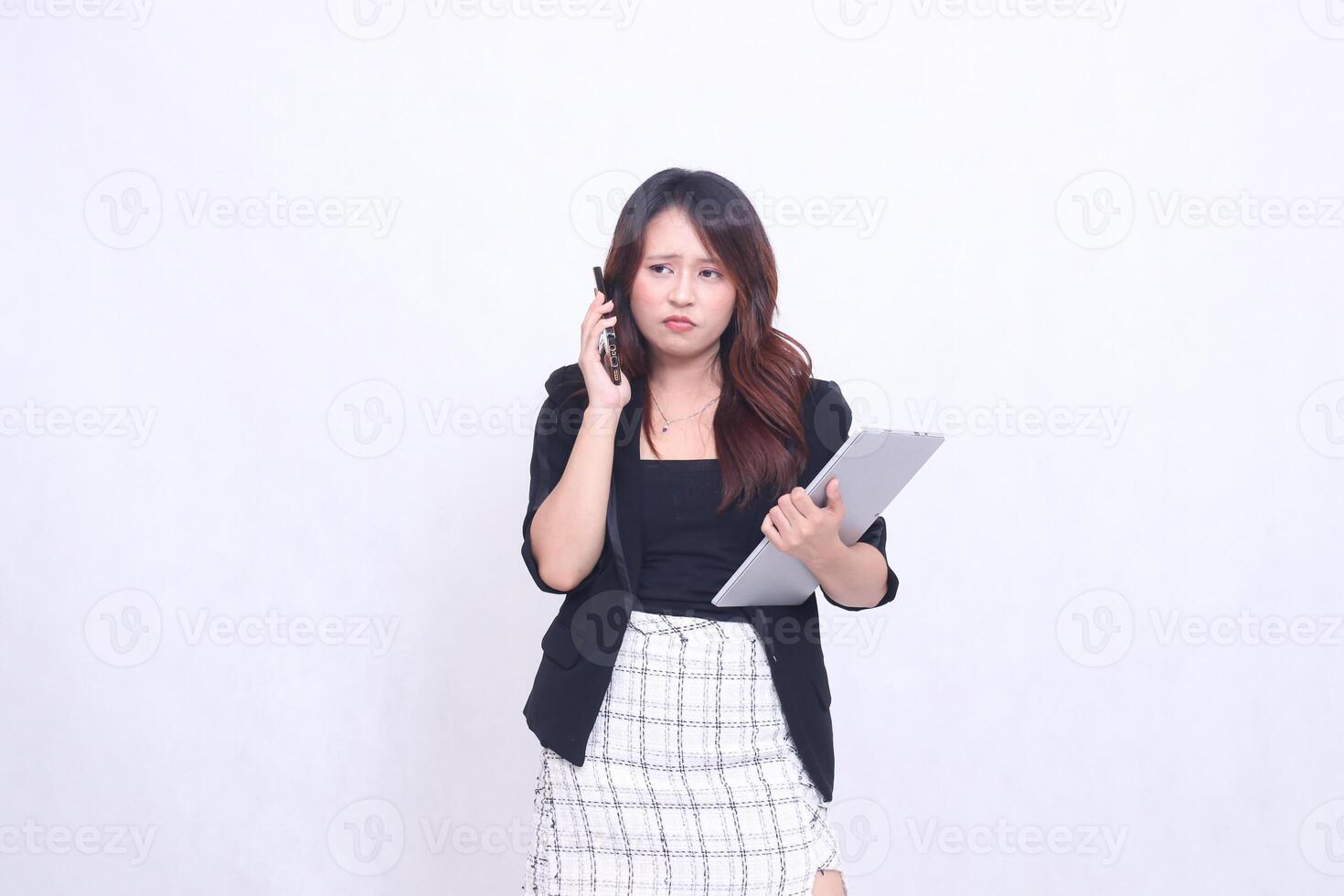 beautiful Indonesian woman 20s formal office pouting phone via black cellphone gadget candid and carrying tablet for promo isolated white background photo