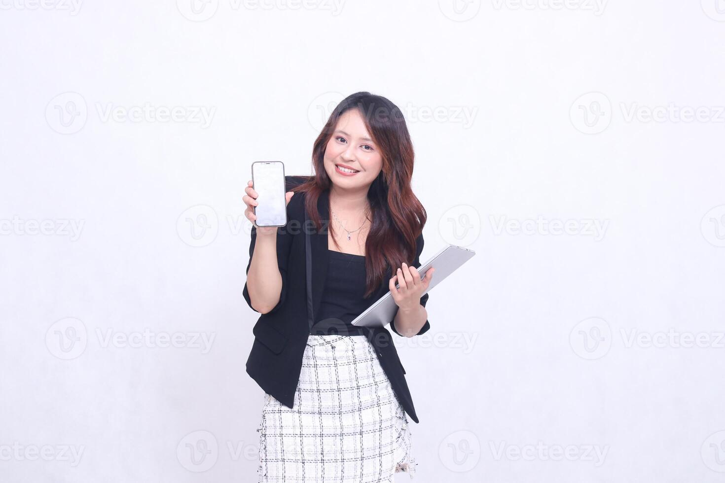 Beautiful Southeast Asian woman 20s formal office elegant smile looking at cellphone gadget screen and carrying tablet for promo isolated white background photo