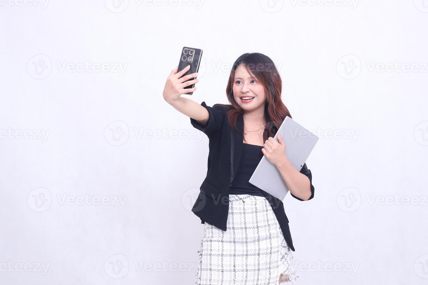 beautiful Indonesian woman 20s formal office happy cheerful call via black cellphone gadget candid and bring tablet for promo isolated white background photo