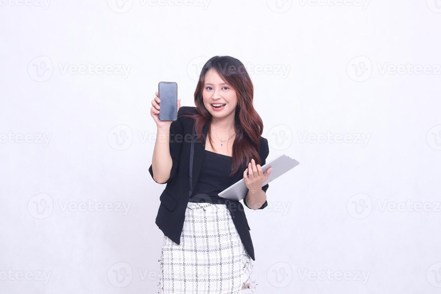 beautiful southeast asian girl 20s formal office happy smile looking at cellphone gadget screen and carrying tablet for promo isolated white background photo