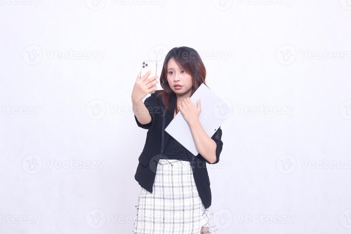 hermosa Sureste asiático mujer 20s formal oficina plano sonrisa mirando a Teléfono móvil y que lleva tableta para promoción aislado blanco antecedentes foto