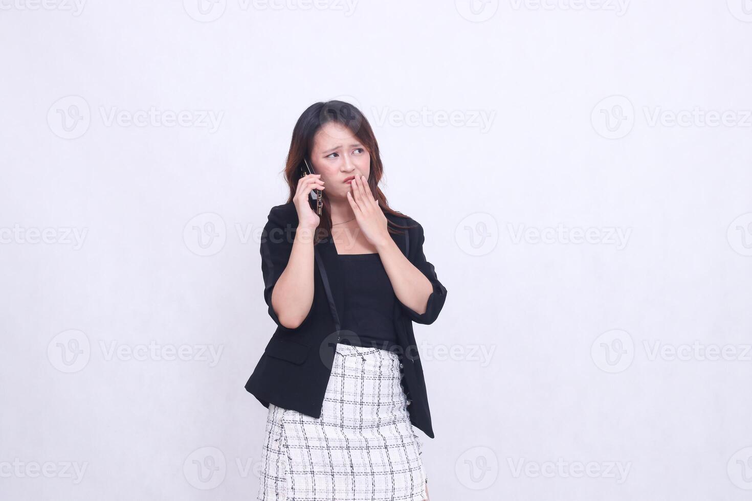 Asian office woman in her 20s, an expression of disgust while making a telephone call using a cellphone gadget for promos while her hand covers her mouth photo