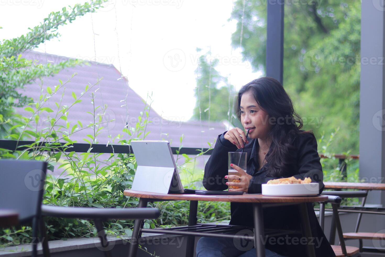 The elegance of young Asian office girl shopping online while doing work and drinking candidly at the cafe photo