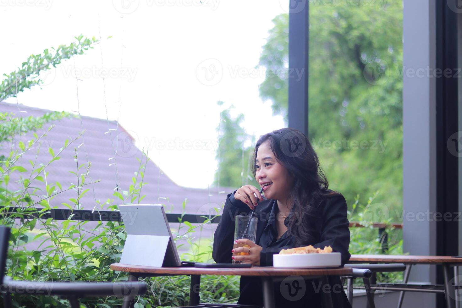 elegance of young asian office woman smiling online shopping while doing work and drinking candid in cafe photo
