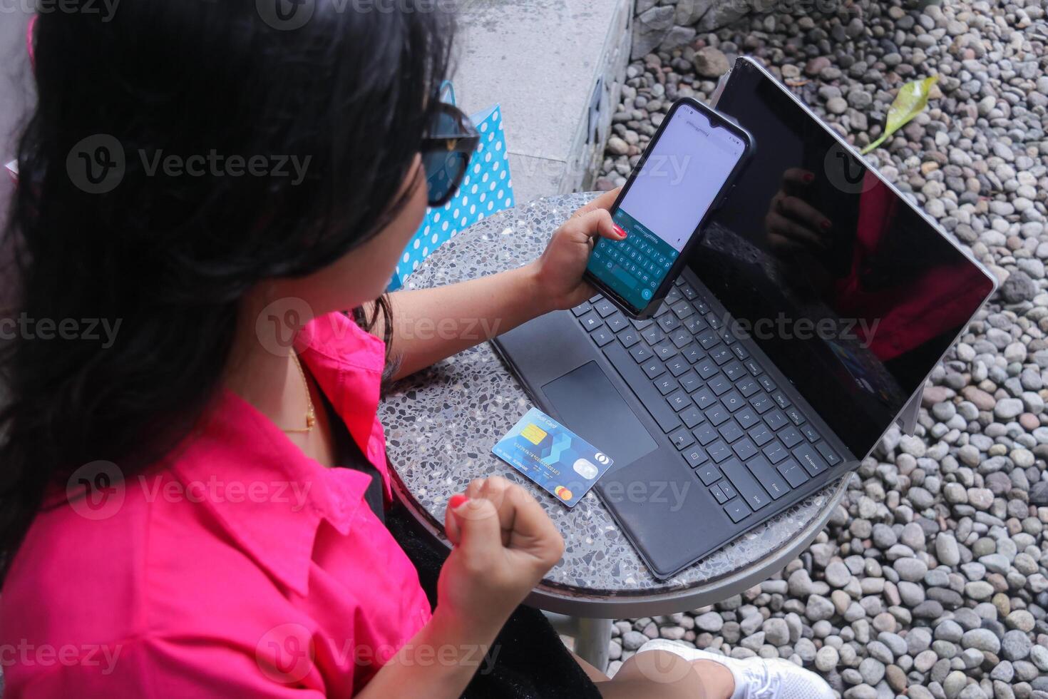 elegance of young Asian girl wearing glasses successfully entering shopping voucher code via laptop with credit card for promotional content, fashion, business, marketing photo