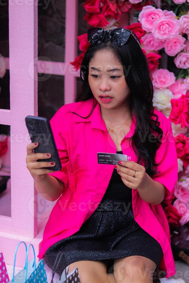 beautiful asian girl in pink shirt surprised when checking out shopping to get a discount for promotion of fashion, lifestyle, catalog photo