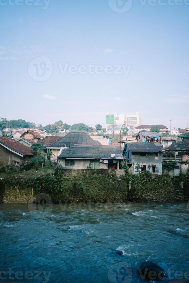 The Ciliwung River in Bogor, flowing through lush greenery and urban landscapes. photo