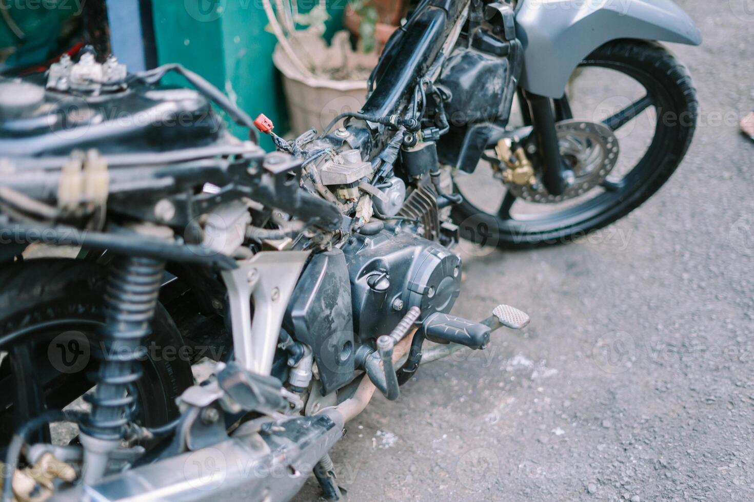 A motorcycle mechanic is checking a damaged engine photo