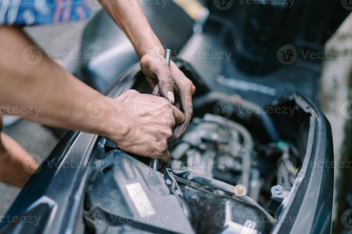 A motorcycle mechanic is checking a damaged engine photo