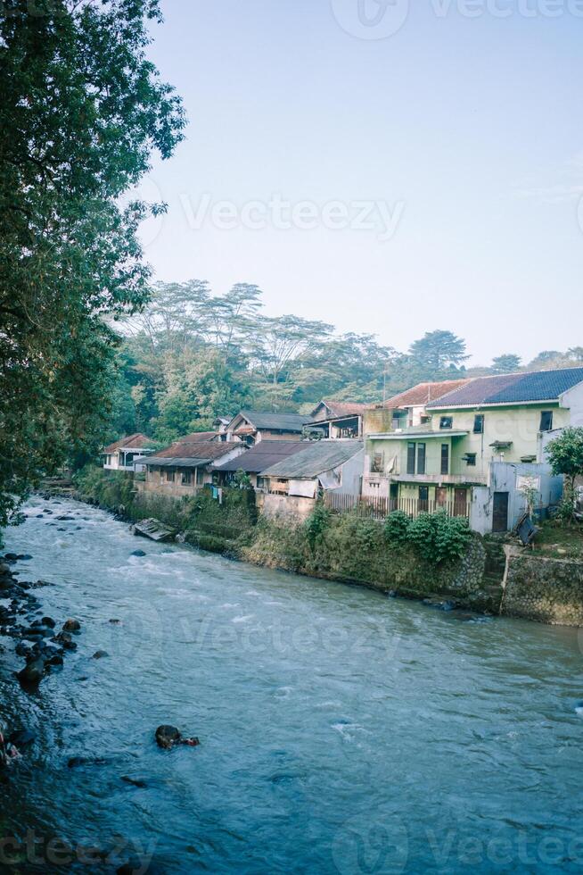 The Ciliwung River in Bogor, flowing through lush greenery and urban landscapes. photo
