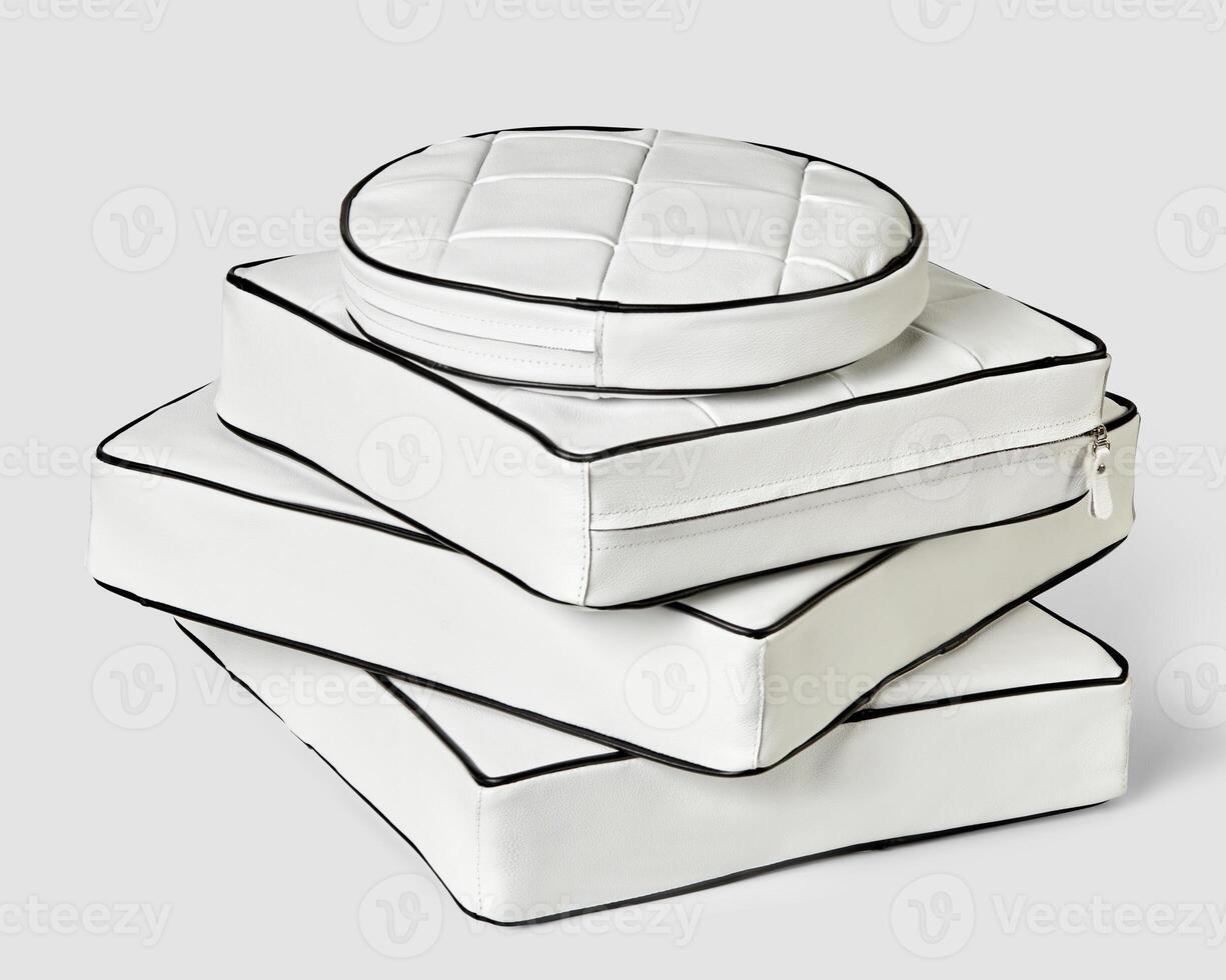 Stack of minimalist square and round white leather seat cushions photo