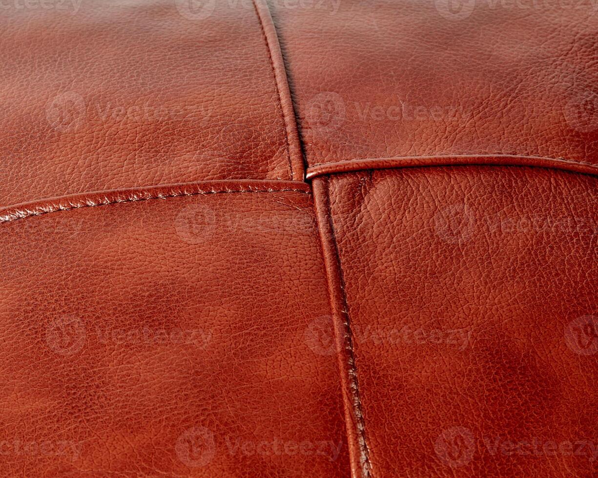 Background of stitched square patches of copper-coloured leather photo
