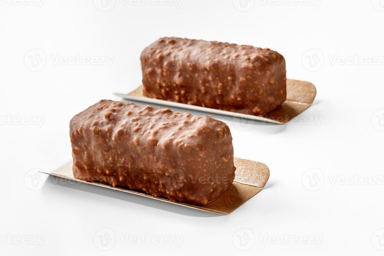 Two nuts and chocolate covered ice cream bars on white photo